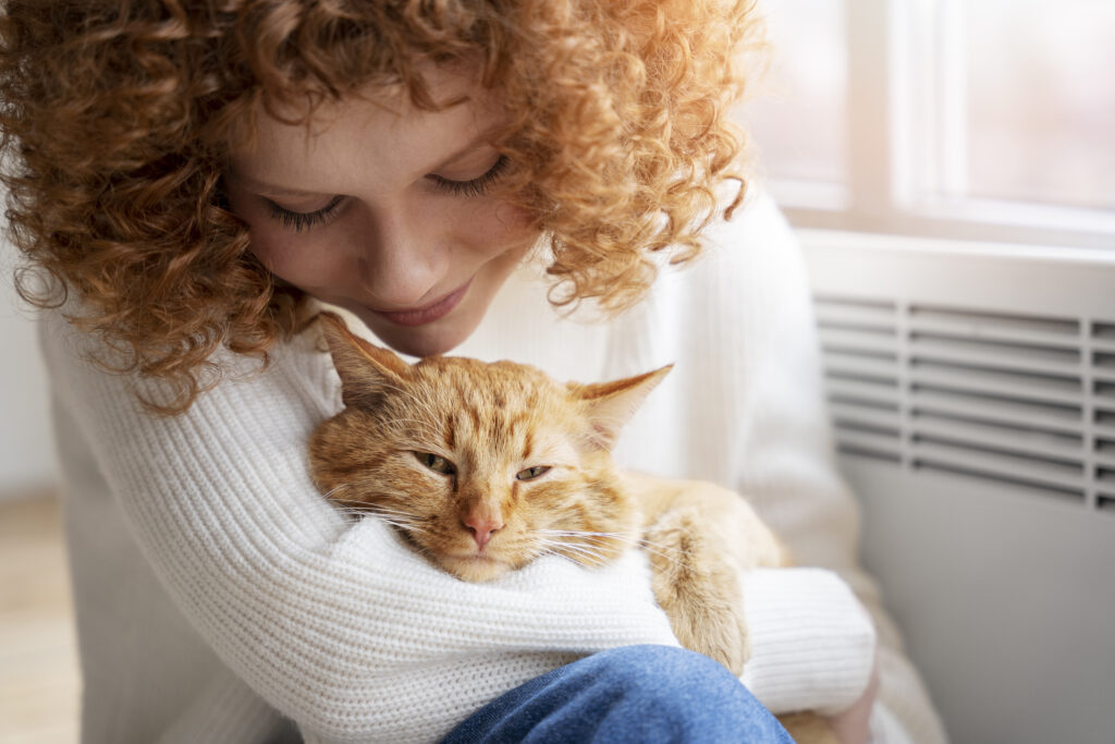 CatTalk Frau kuschelt mit roter Katze und hält sie im Arm